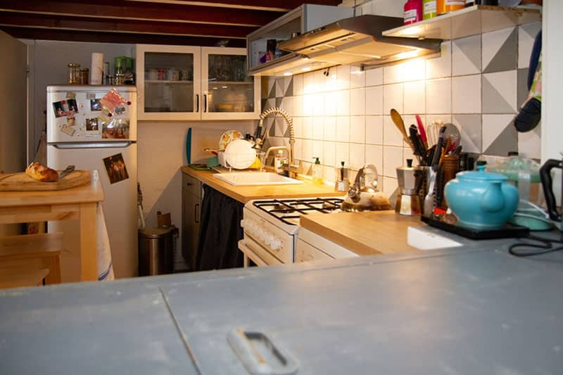 A kitchen with white tile backsplash