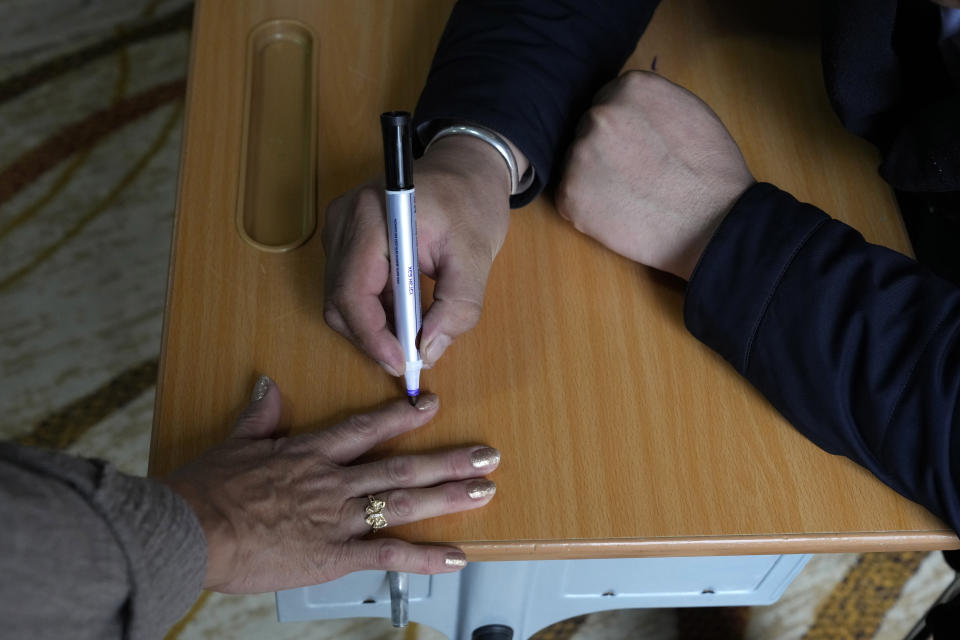 An electoral worker marks the finger of a voter after she casts her votes at a polling station in Ulaanbaatar, Mongolia, Friday, June 28, 2024. Voters in Mongolia are electing a new parliament on Friday in their landlocked democracy that is squeezed between China and Russia, two much larger authoritarian states (AP Photo/Ng Han Guan)