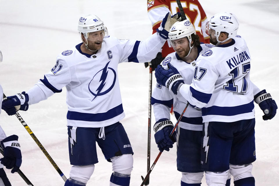 Tampa Bay Lightning center Brayden Point, center, celebrates with center Steven Stamkos (91) and left wing Alex Killorn (17) after scoring a goal during the third period of an NHL hockey game against the Florida Panthers, Sunday, April 24, 2022, in Sunrise, Fla. The Lightning won 8-4. (AP Photo/Lynne Sladky)