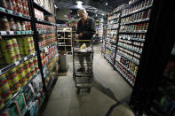 In this March 24, 2020, photo David Leeson, of Winterset, Iowa, shops at the Gateway Market in Des Moines, Iowa. While most governors have imposed stay-at-home orders to slow the spread of the coronavirus, leaders of a handful of states have rejected such action. (AP Photo/Charlie Neibergall)