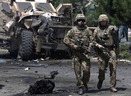 NATO soldiers walk at the site of a suicide bomb attack in Kabul, Afghanistan June 30, 2015. REUTERS/Ahmad Masood