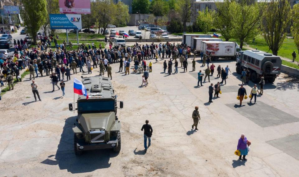 Local people and refugees from Donetsk region line up for humanitarian aid distributed from Russian military trucks in Berdyansk (AFP/Getty)