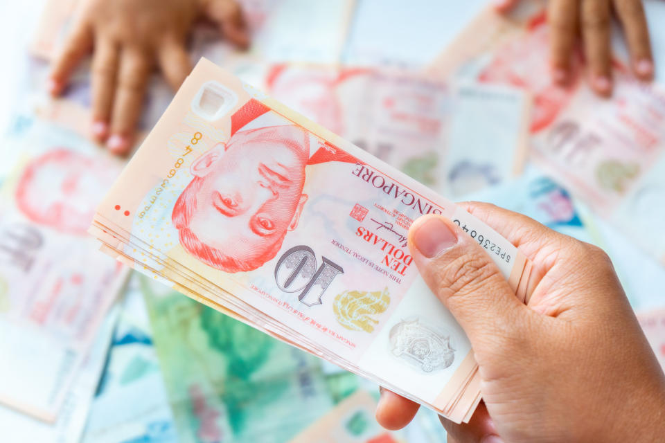 Hand holding Singapore Dollar banknote,Background