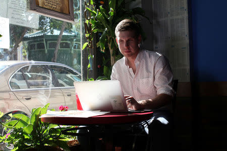 Reuters journalist Nick Brown works at his laptop at a cafe in San Juan, Puerto Rico, August 8, 2016. REUTERS/Alvin Baez