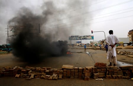 A Sudanese protester stands near a barricade on a street, demanding that the country's Transitional Military Council handover power to civilians, in Khartoum