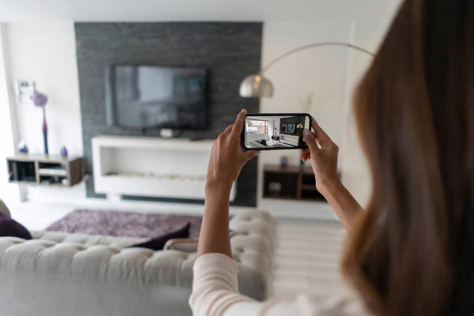 A woman photographing a room.