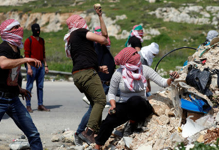 Palestinian protesters hurl stones at Israeli troops during clashes near the Jewish settlement of Beit El, in the Israeli-occupied West Bank March 20, 2019. REUTERS/Mohamad Torokman