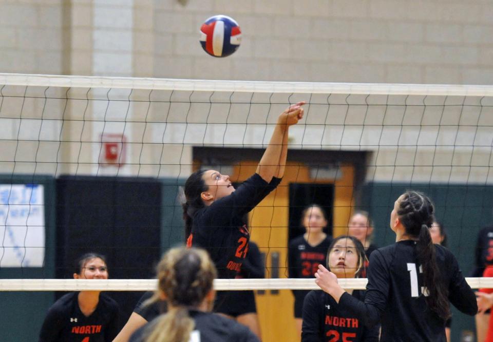 North Quincy's Autumn O'Campos, center, digs a Marshfield shot during girls volleyball at Marshfield High School, Wednesday, Oct. 26, 2023.