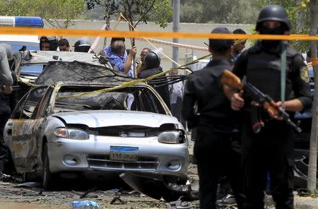 Policemen secure the site of a car bomb attack on the convoy of Egyptian public prosecutor Hisham Barakat near his house at Heliopolis district in Cairo, June 29, 2015. REUTERS/Mohamed Abd El Ghany