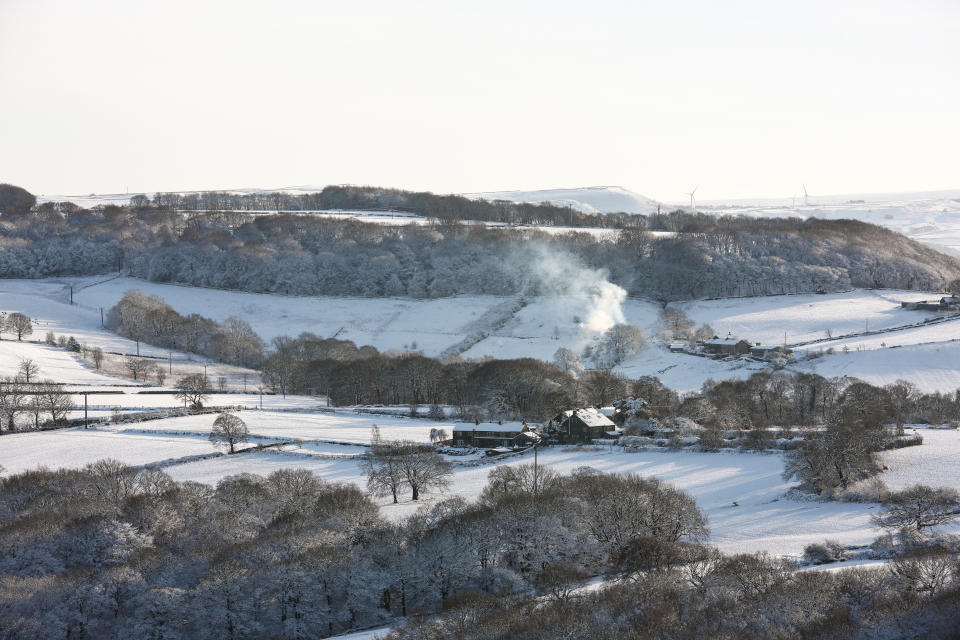 HUDDERSFIELD, UNITED KINGDOM - 2021/01/15: Smoke rises from a chimney in the snow-covered West Yorkshire landscape. Many parts of West Yorkshire are still covered with snow following heavy snowfall the previous day, which caused widespread disruption to travel. (Photo by Adam Vaughan/SOPA Images/LightRocket via Getty Images)