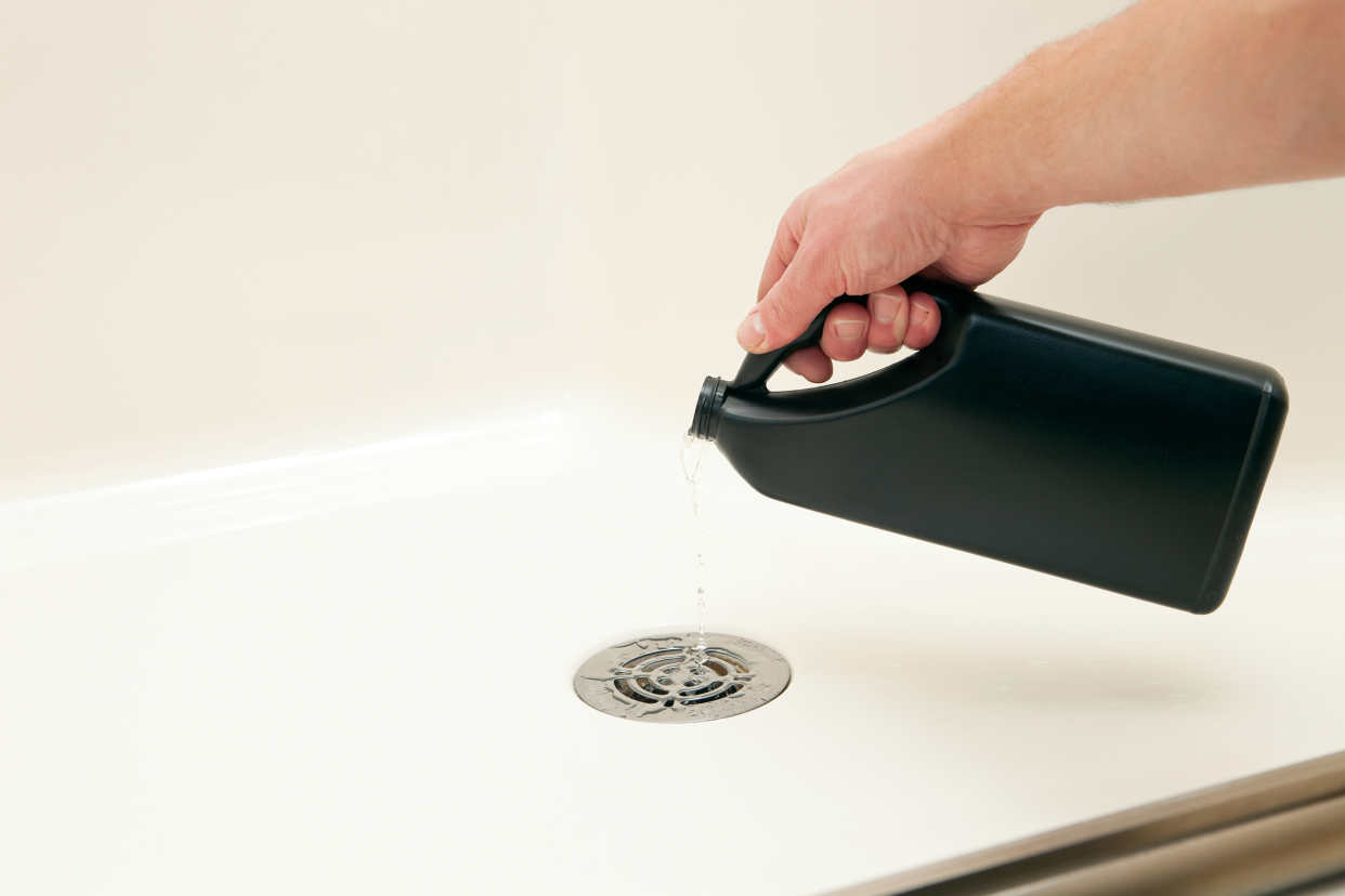 Pouring drain cleaner in a sink