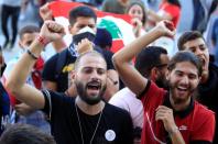 Anti-government demonstrators gesture and chant slogans during a protest as Lebanese mark one year since the start of nation-wide protests in Beirut