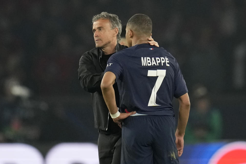 Kylian Mbappé del Paris Saint-Germain recibe el consuelo del técnico Luis Enrique durante el partido de vuelta de la semifinal contra el Borussia Dortmund por la Liga de Campeones, el martes 7 de mayo de 2024. (AP Foto/Christophe Ena)