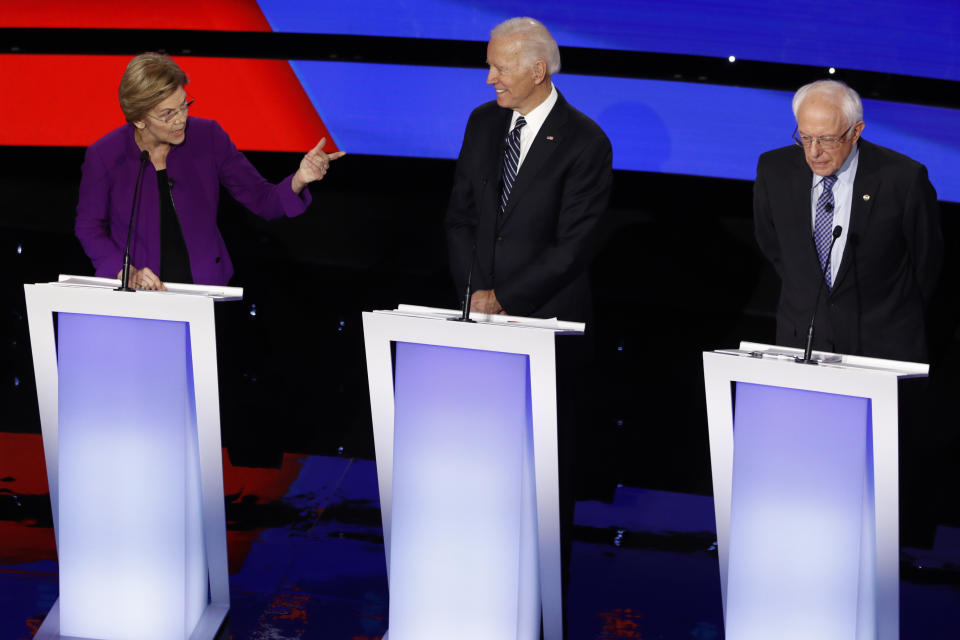 Democratic presidential candidate Sen. Elizabeth Warren, D-Mass., left, speaks to candidate Sen. Bernie Sanders, I-Vt., right as former Vice President Joe Biden watches Tuesday, Jan. 14, 2020, during a Democratic presidential primary debate hosted by CNN and the Des Moines Register in Des Moines, Iowa. (AP Photo/Patrick Semansky)