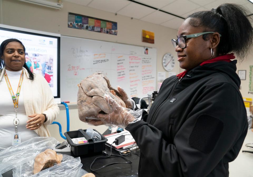 Gift of Life Community Relations Coordinator Taneisha Carswell, 41, of Macomb, left, looks on as Jelisa Barginere, 17, a senior at Renaissance High School in Detroit, takes a look at a preserved set of lungs and heart on Tuesday, Jan. 30, 2024 during her biology class. The class was being taught the importance and impact of organ donations.