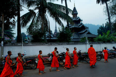 Boys walks for almsgiving early morning after entering the Buddhist novicehood at a temple where they live for one or two months during their school holidays, studying Buddhist scripture, in Mae Hong Son, Thailand, April 15, 2018. REUTERS/Jorge Silva