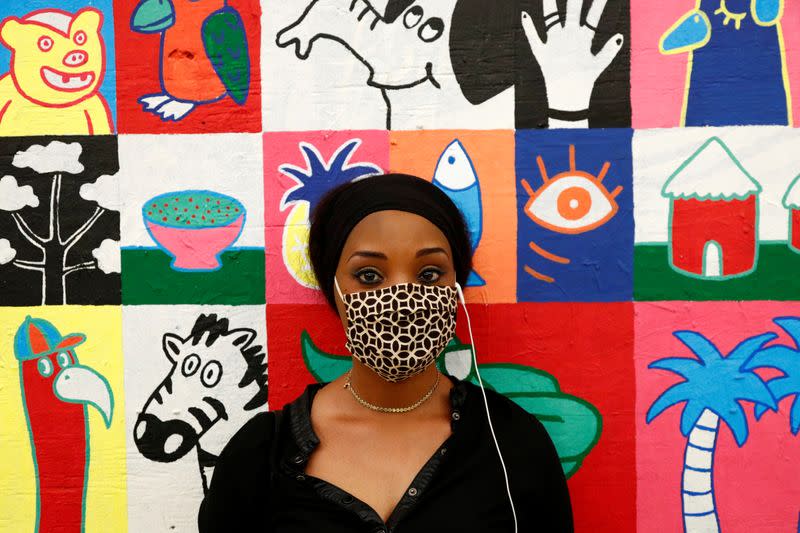 A woman poses in front of a painting in the Matonge district in Brussels