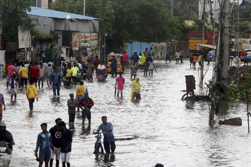 People wade through a flooded street in Chennai, India, Wednesday, Nov.25, 2020. India’s southern state of Tamil Nadu is bracing for Cyclone Nivar that is expected to make landfall on Wednesday. The state authorities have issued an alert and asked people living in low-lying and flood-prone areas to move to safer places. (AP Photo/R. Parthibhan)