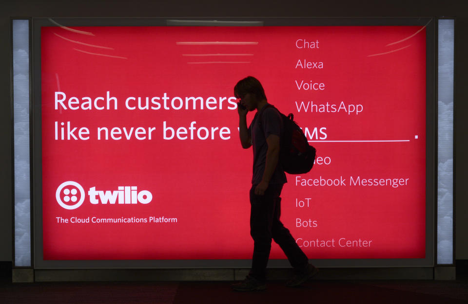 SAN FRANCISCO, CALIFORNIA - SEPTEMBER 17, 2018:  A passenger waiting to board his plane walks in front of a sign advertising Twilio at San Francisco International Airport in San Francisco, California. Twilio is a cloud communications platform based in San Francisco. (Photo by Robert Alexander/Getty Images)