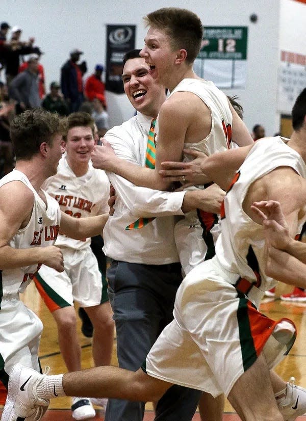 East Lincoln's Andrew Fann celebrates with John Bean following their 74-65 win over East Rutherford during a 2019 NCHSAA 2A boys basketball playoff game.