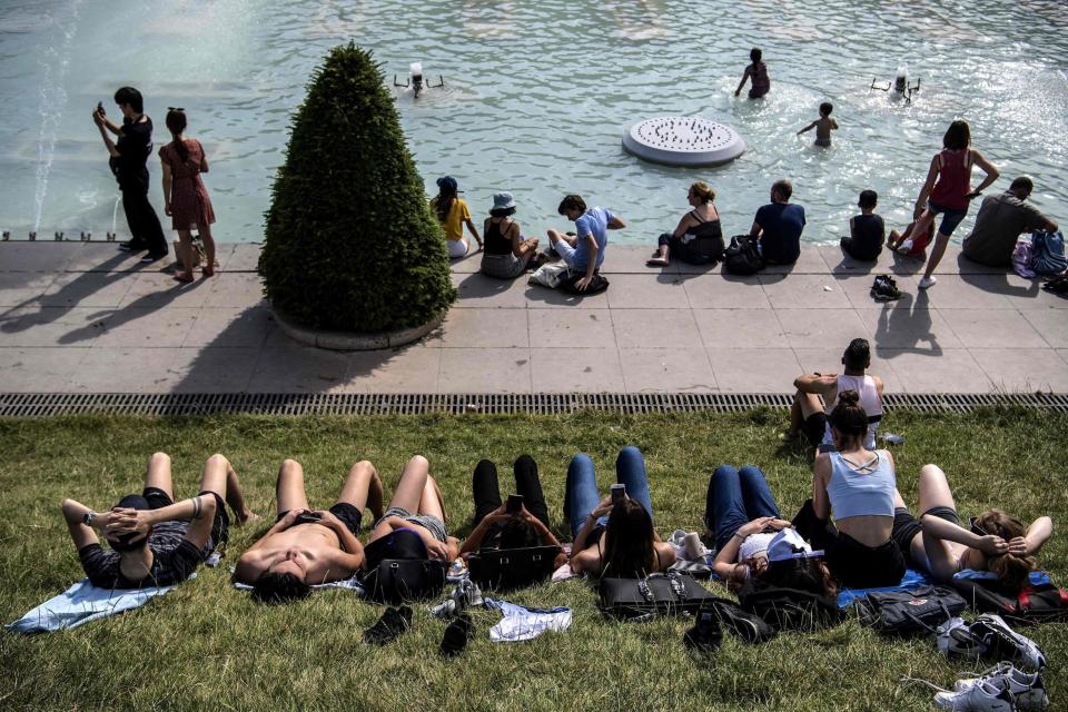 Youngsters sunbathe and cool themselves down in a pond at the Trocadero esplanade in Paris (AFP/Getty Images)