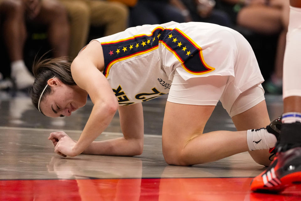 Indiana Fever guard Caitlin Clark (22) grimaces after being injured in the first half of a WNBA basketball game against the Connecticut Sun in Indianapolis, Monday, May 20, 2024. (AP Photo/Michael Conroy)