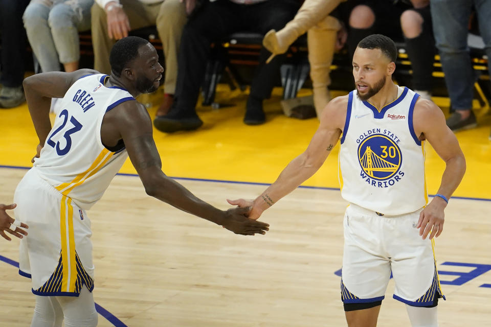 Golden State Warriors guard Stephen Curry (30) is congratulated by forward Draymond Green (23) after scoring against the Dallas Mavericks during the first half of Game 2 of the NBA basketball playoffs Western Conference finals in San Francisco, Friday, May 20, 2022. (AP Photo/Jeff Chiu)