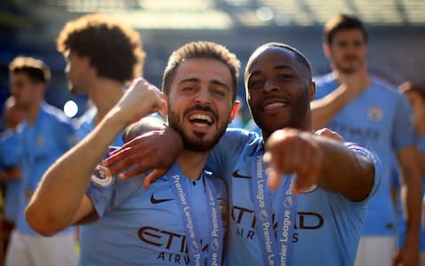 Bernardo Silva and Raheem Sterling of Manchester City celebrate after winning the title following the Premier League match between Brighton & Hove Albion and Manchester City - Credit: &nbsp;Tom Flathers/Manchester City FC