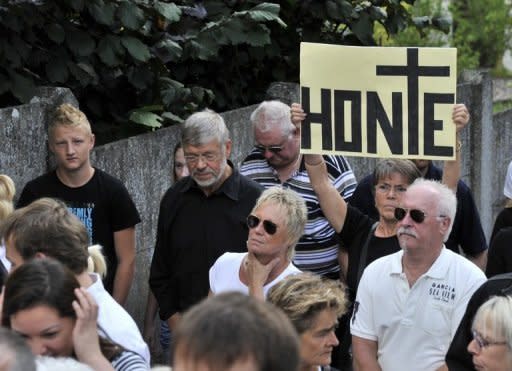 Protesters hold a banner reading 'Shame' during a protest outside a convent in Malonne that has agreed to house on parole Michelle Martin, the ex-wife and accomplice of notorious Belgian paedophile serial killer Marc Dutroux
