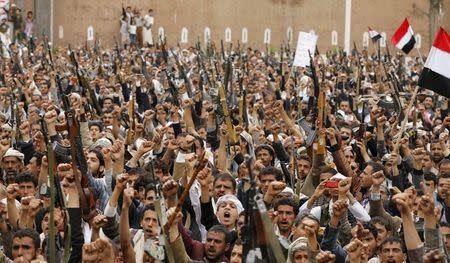 Shi'ite Muslim rebels hold up their weapons during a rally against air strikes in Sanaa March 26, 2015. REUTERS/Khaled Abdullah