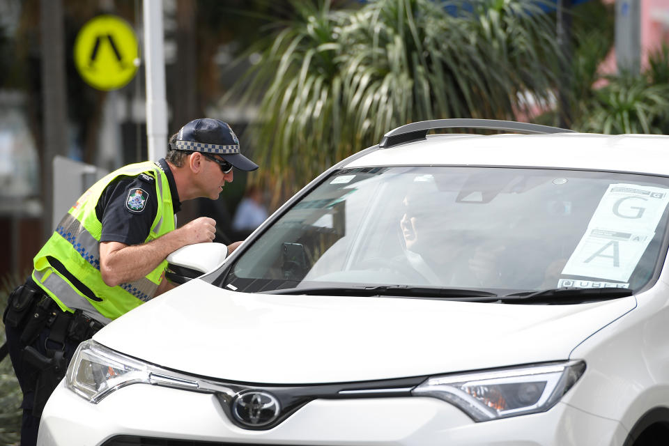 A police officer stops a motorist at a border check. 