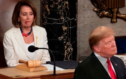 Nancy Pelosi looks unimpressed at Mr Trump's remarks - Credit: AFP