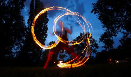 A man performs with fire at Friedrichshain Park in Berlin, Germany, August 28, 2016. Berlin is home to many performers, who put on their shows at bars, clubs and other venues. REUTERS/Hannibal Hanschke