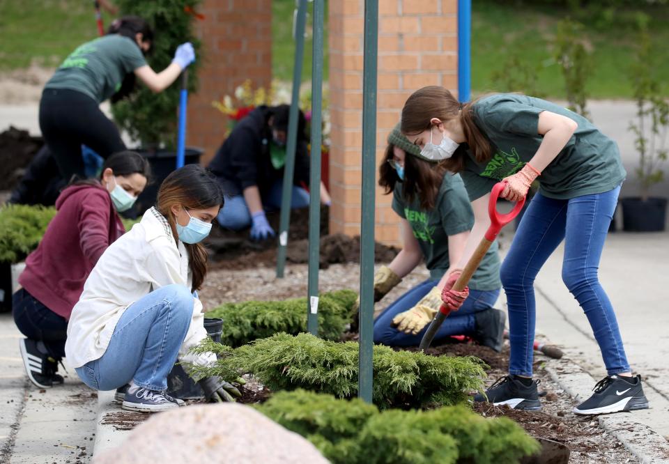 Elizabeth Pantoga-Montoto, 17, front left, and 
Jaqueline Sandoval-Ramerez, 15, plant shrubs as part of the Teens Grow Greens program at the Sixteenth Street Community Health Center at 4570 S. 27th St. in Milwaukee on May 15, 2021.