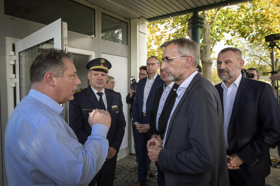 Hotel operator Kevin Stalula, left, welcomes Saxony's Interior Minister Armin Schuster at the Spree Hotel in Bautzen, Germany, Saturday Oct. 29, 2022. The week before the arrival of refugees from Ukraine, a suspected arson attack occurred on the building. (Heiko Rebsch/dpa via AP).