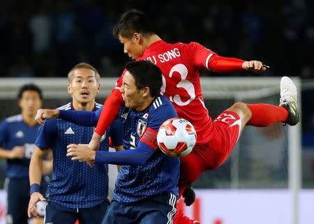 Soccer Football - East Asian Football Championship - North Korea v Japan - Ajinomoto Stadium, Tokyo, Japan - December 9, 2017. North Korea's Kim Yu Song (R) and Japan's Gen Shoji in action. REUTERS/Toru Hanai