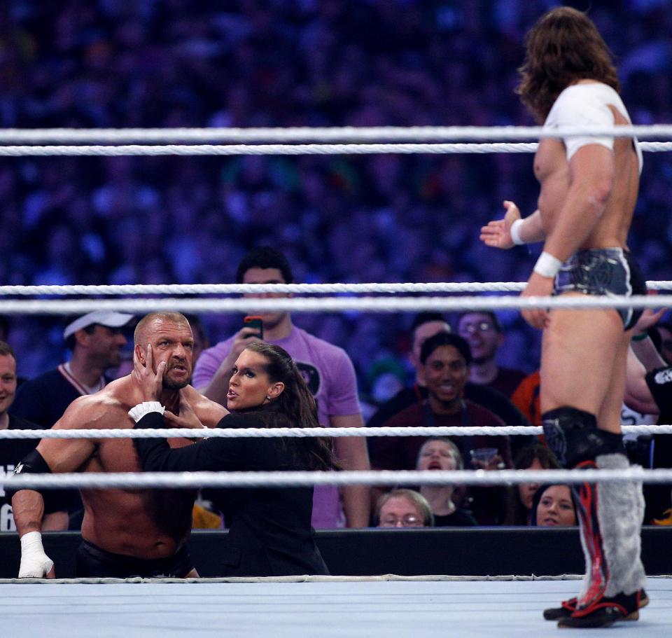 Triple H, left, is held back by Stephanie McMahon, while being taunted by Daniel Bryan during Wrestlemania XXX at the Mercedes-Benz Super Dome in New Orleans on Sunday, April 6, 2014. (Jonathan Bachman/AP Images for WWE)