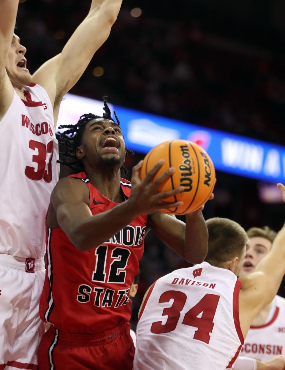 Dec 29, 2021; Madison, Wisconsin, USA;Illinois State Redbirds guard Antonio Reeves (12) shoots as Wisconsin Badgers center Chris Vogt (left) defends  during the first half at the Kohl Center. Mandatory Credit: Mary Langenfeld-USA TODAY Sports