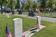 Motorcyclists ride past the graves of veterans at Mountview Cemetery on Memorial Day in Billings, Mont., Monday, May 25, 2020. A public ceremony to mark Memorial Day was replaced this year by a drive-by motorcycle procession by members of the Yellowstone Legion Riders and others. (AP Photo/Matthew Brown)