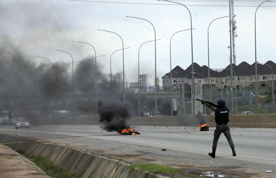 A policeman fire teargas at protesters during a protest in Abuja Nigeria Wednesday Sept. 4, 2019. South African-owned businesses operating in Nigeria are being targeted with violence in retaliation for xenophobic attacks carried out against Africans working in South Africa. Police in South African arrested more than 100 people in five areas impacted by days of violence in Johannesburg and Pretoria. (AP Photo)