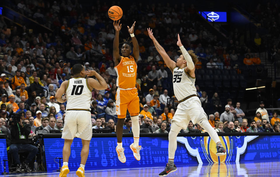 Tennessee guard Jahmai Mashack (15) shoots a 3-point buzzer-beater between the defense of Missouri guard Nick Honor (10) and forward Noah Carter (35) to end the first half of an NCAA college basketball game in the third round of the Southeastern Conference tournament, Friday, March 10, 2023, in Nashville, Tenn. (AP Photo/John Amis)