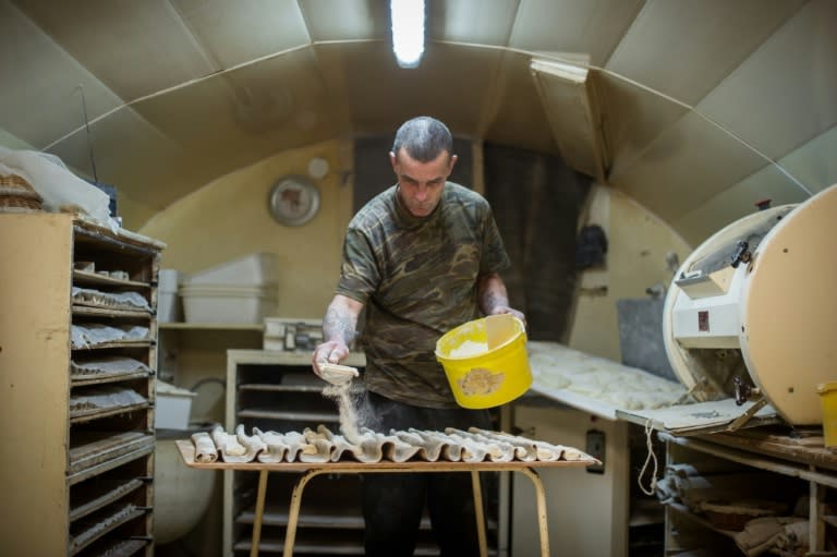 Jerome Aucant, who used to be homeless, works in the bakery he bought for one euro from Michel Flamant in Dole, eastern France