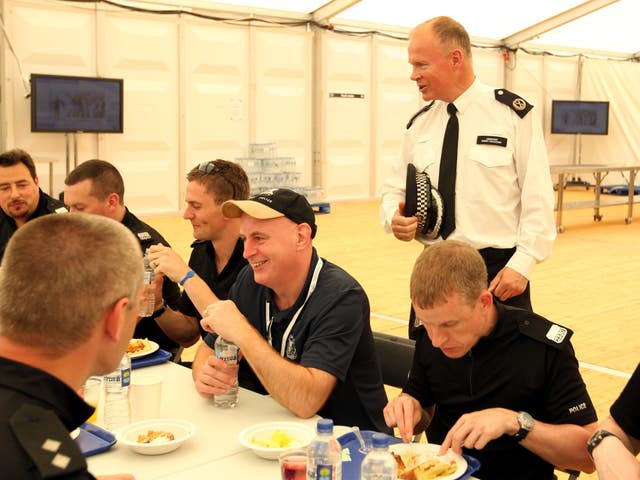 Commander Bob Broadhurst standing next to a table where police officers are eating.