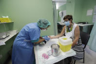 A school teacher sits for a blood COVID-19 test at the San Carlo Hospital in Milan, Italy, Wednesday, Aug. 26, 2020. Despite a spike in coronavirus infections, authorities in Europe are determined to send children back to school. Italy, Europe’s first virus hot spot, is hiring 40,000 more temporary teachers and ordering extra desks, but some won’t be ready until October. (AP Photo/Luca Bruno)