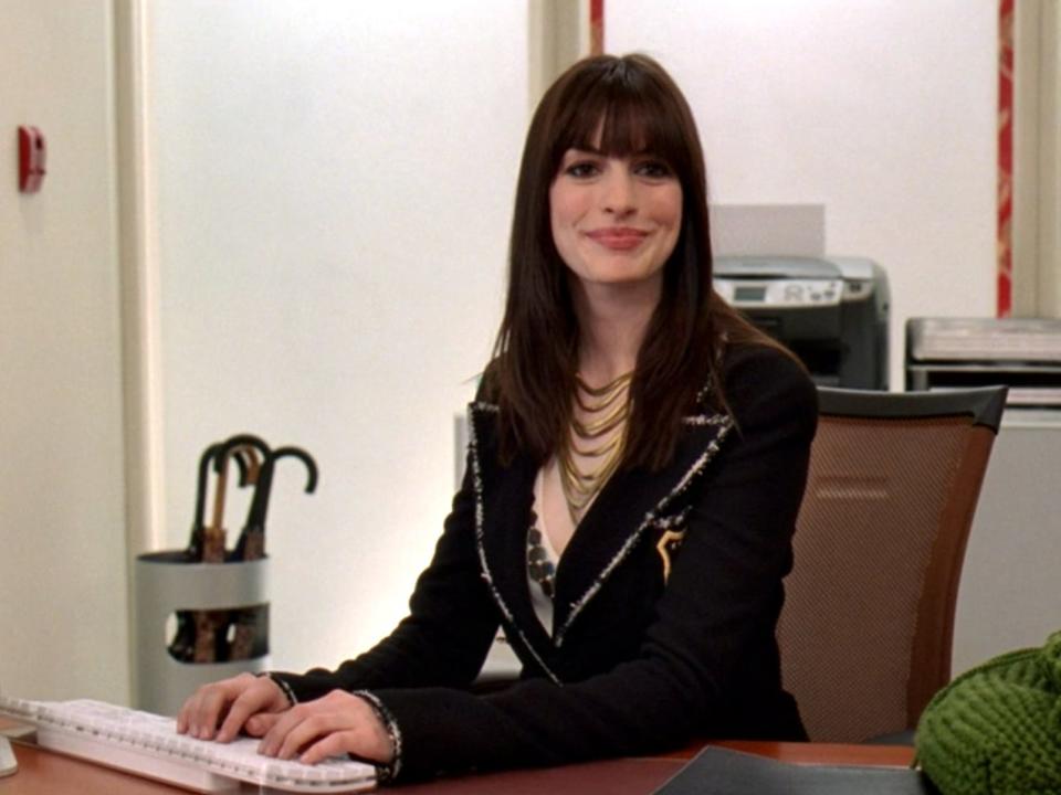 Anne Hathaway typing at a desk in "The Devil Wears Prada."