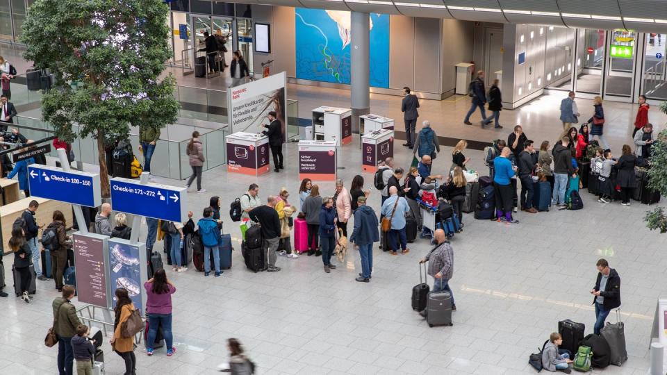 Gestrandete Fluggäste vor einem Serviceschalter am Flughafen Düsseldorf.