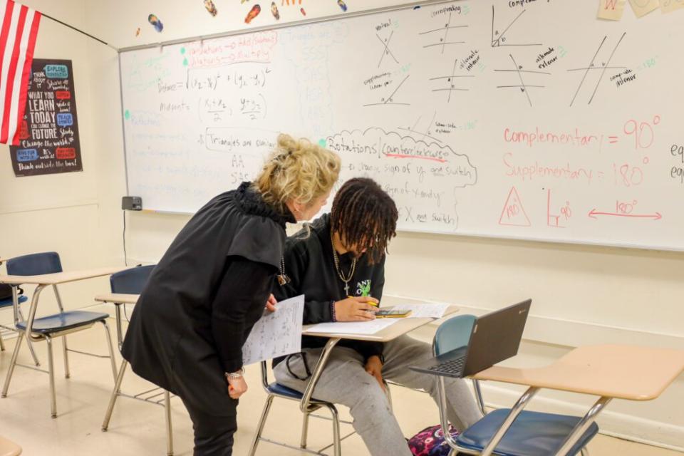 Powell helps a student with a classwork assignment. She uses Reeves’ solutions key. (Cheyenne McNeill/EducationNC)