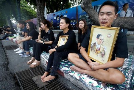 People mourning for the late King Bhumibol Adulyadej wait along a procession route near the Grand Palace in Bangkok, Thailand October 14, 2016. REUTERS/Edgar Su