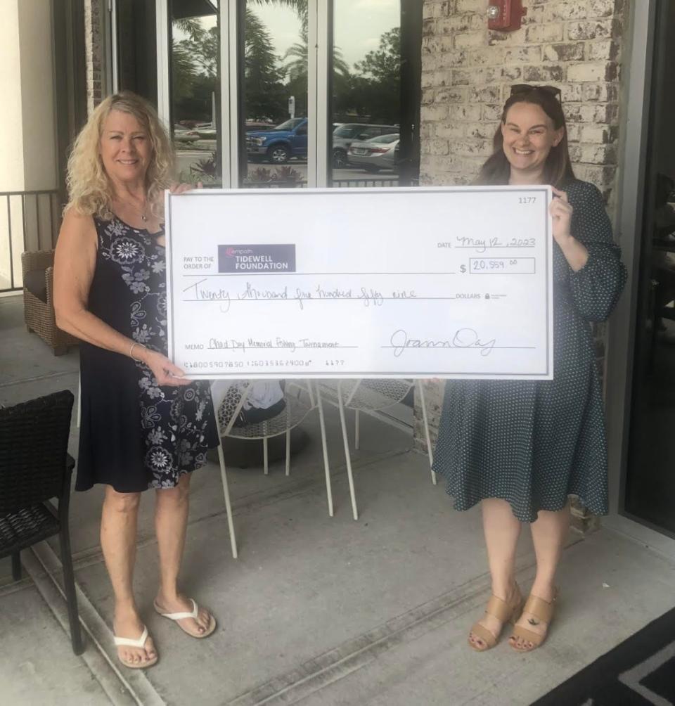 Joann Day, left, presents a check for $20,559 to Megan Wenger, the senior philanthropy advisor for Tidewell Foundation