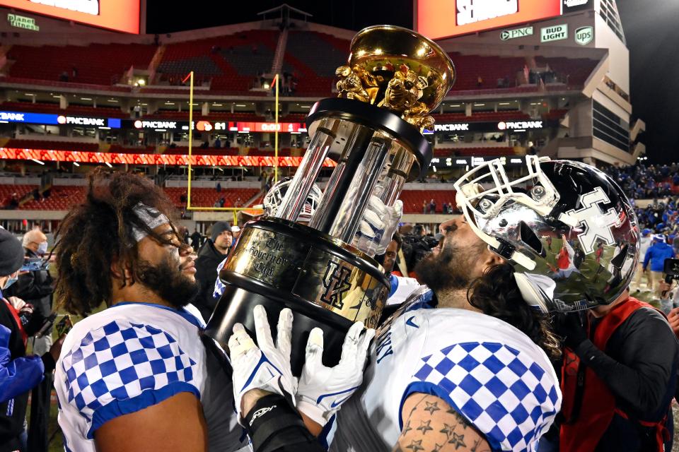 Kentucky defensive end Isaiah Gibson (96) and guard Austin Dotson (61) hold up the Governor's Cup following their victory over Louisville in an NCAA college football game in Louisville, Ky., Saturday, Nov. 27, 2021.